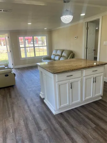 a living room with granite countertop a sink and a wooden floor