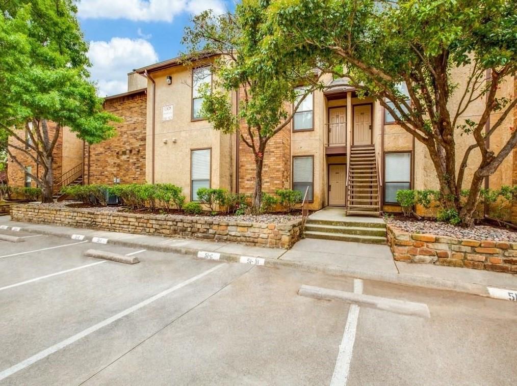 View of property featuring uncovered parking and stairs