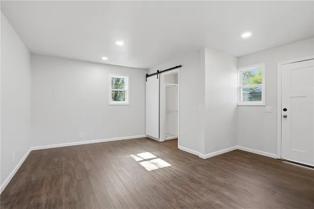 a view of empty room with wooden floor and window