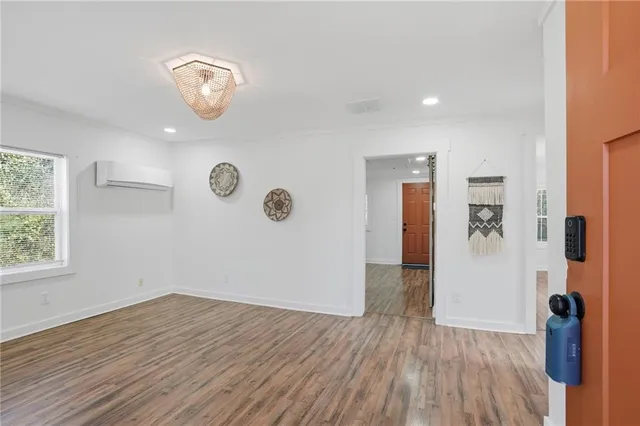 an empty room with wooden floor and windows