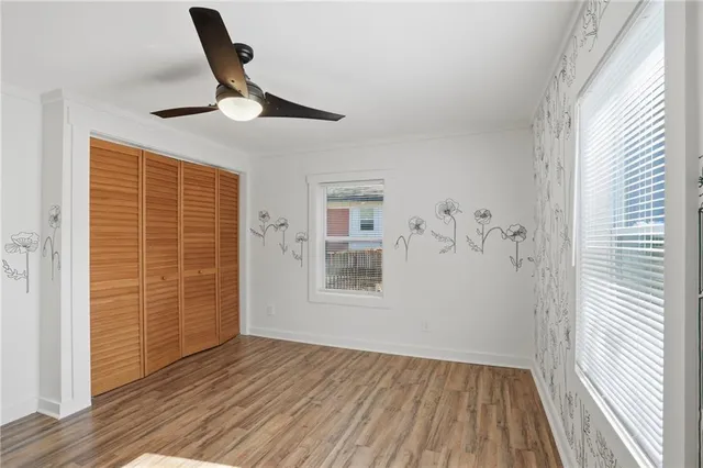 a view of empty room with wooden floor and fan