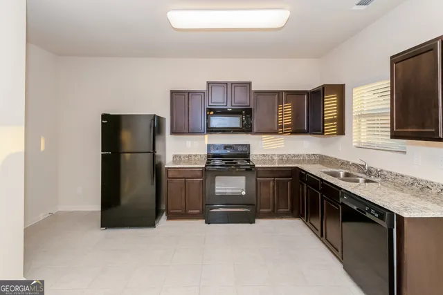 a kitchen with stainless steel appliances granite countertop a refrigerator and a stove top oven