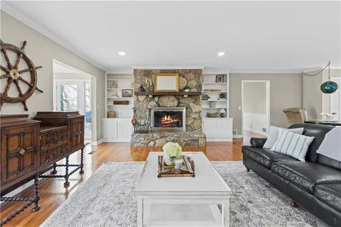 a living room with stainless steel appliances kitchen island granite countertop furniture wooden floor and a view of kitchen