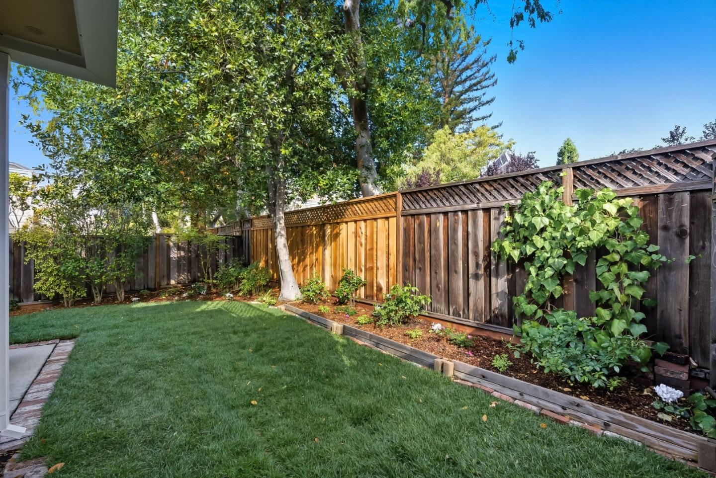 181 Ada Avenue, Unit 29 Mountain View, CA 94043 - Photo 25 of 30 a view of a backyard with potted plants and a large tree