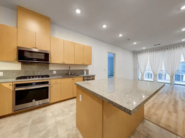 a kitchen with stainless steel appliances granite countertop a sink a stove a microwave a counter top and cabinets