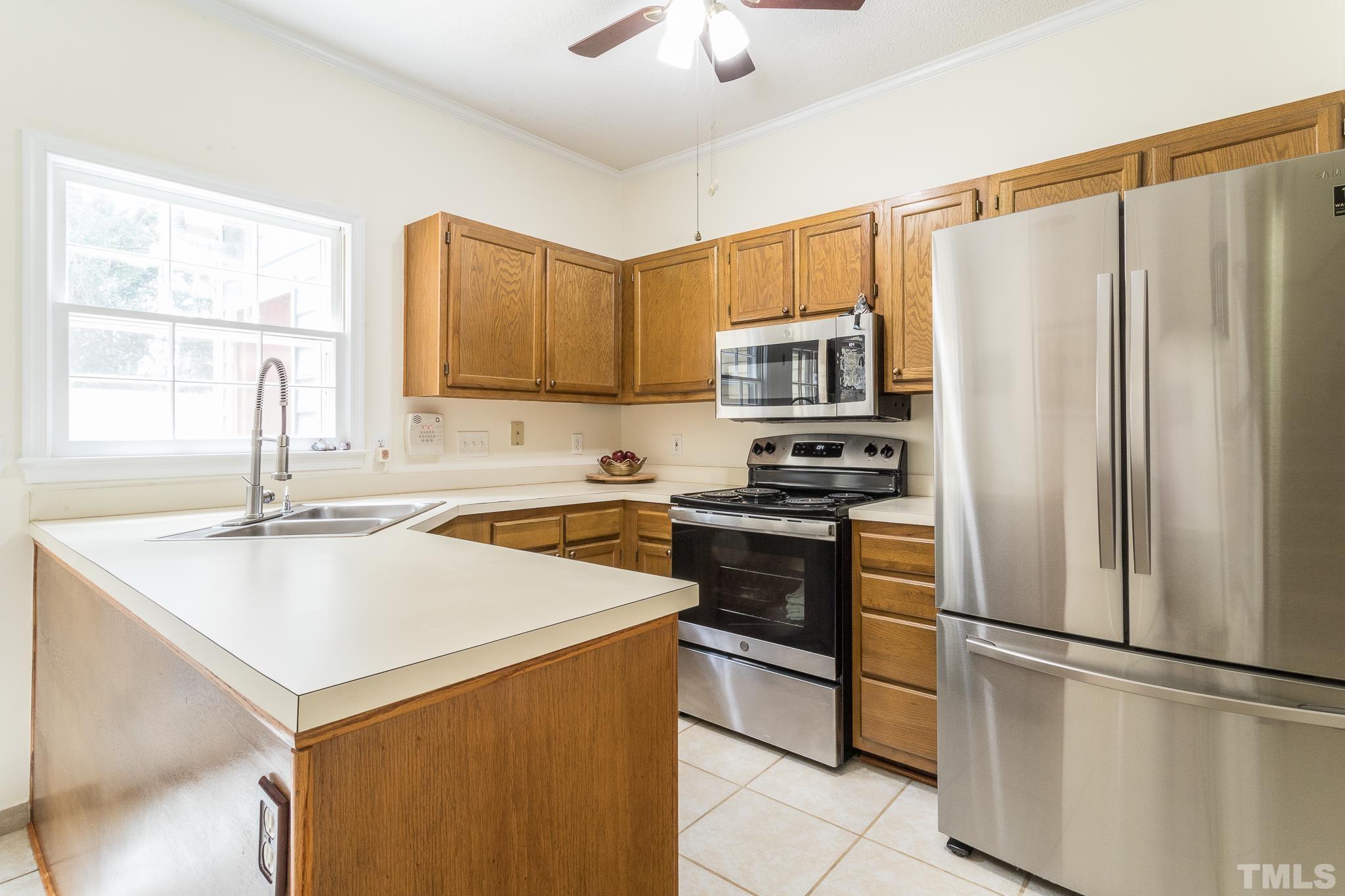 2923 Faversham Place Raleigh, NC 27604 - Photo 6 of 21 a kitchen with a refrigerator a stove a sink a microwave and island