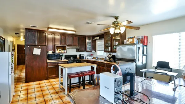 a kitchen that has a table chairs in it and wooden cabinets