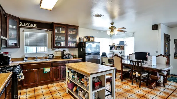a kitchen with a stove a sink a refrigerator and wooden cabinets