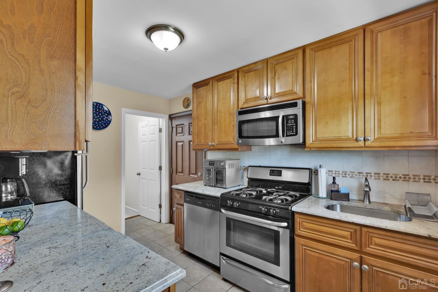 10 Rutgers Road Old Bridge, NJ 08859 - Photo 7 of 18 a kitchen with stainless steel appliances granite countertop a stove a sink and a microwave