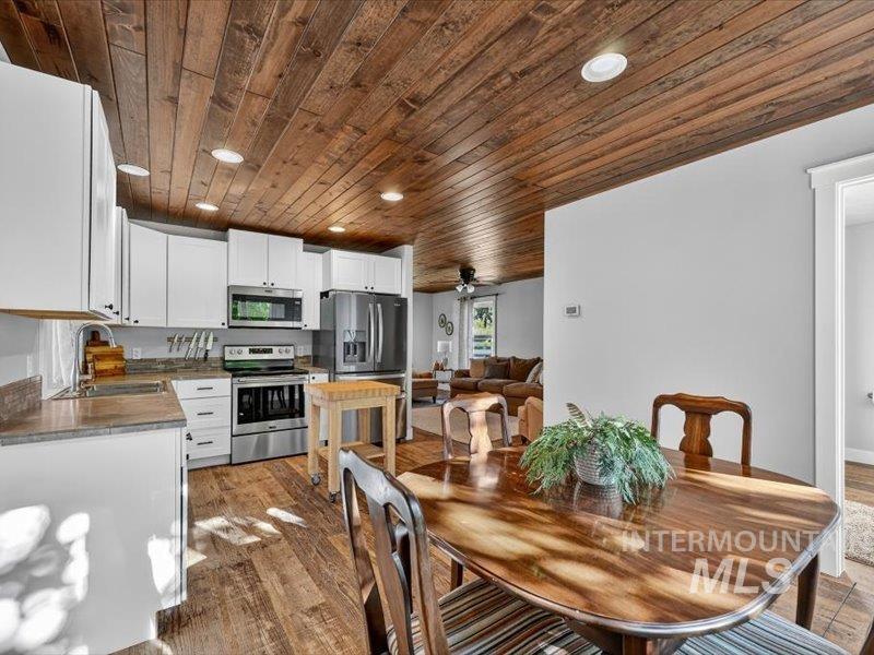 2651 Fruitvale Glendale Road Council, ID 83612 - Photo 11 of 24 Kitchen featuring a wood plank ceiling with recessed lighting, white cabinetry with dark hardware, stone countertops, and stainless steel appliances