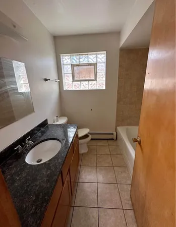 a bathroom with a granite countertop sink and a mirror