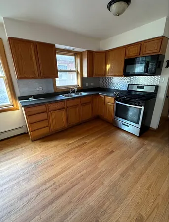 a kitchen with granite countertop a stove and a sink