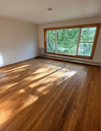 a view of room with window and wooden floor