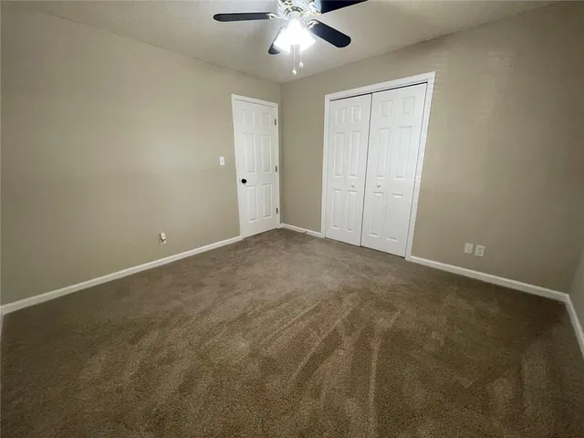 an empty room with a ceiling fan and a window