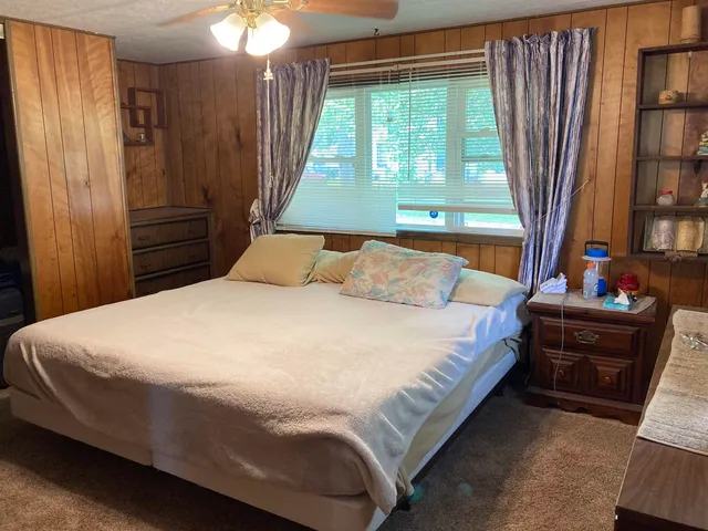 a bed sitting in a bedroom next to a window