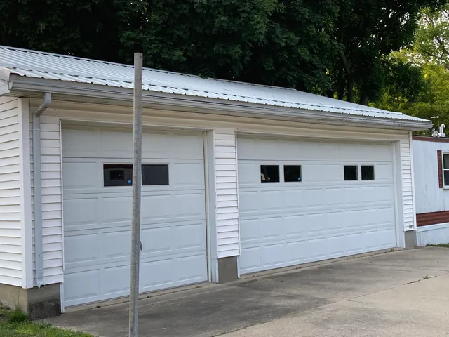 a view of a white house next to a yard