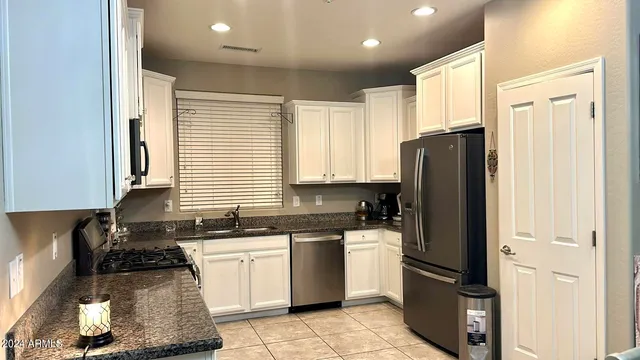 a kitchen with a refrigerator a sink and cabinets