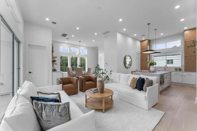 a kitchen with stainless steel appliances kitchen island a table chairs in it and wooden floors