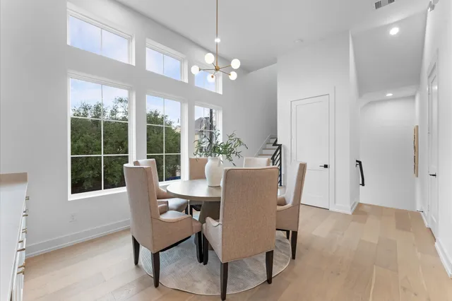a view of a dining room with furniture a chandelier and a large window