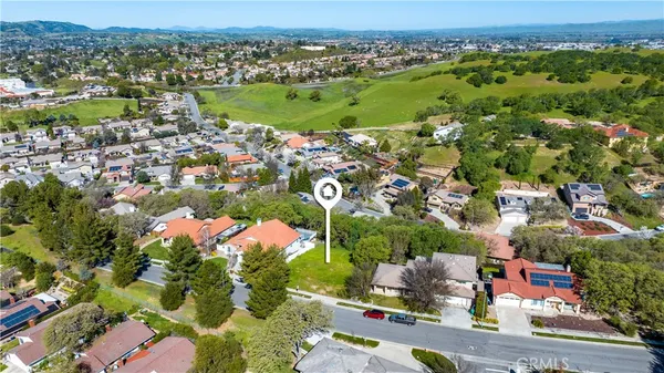 an aerial view of residential houses with outdoor space and trees