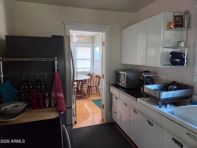 a kitchen with stainless steel appliances granite countertop a refrigerator a stove a sink and white cabinets