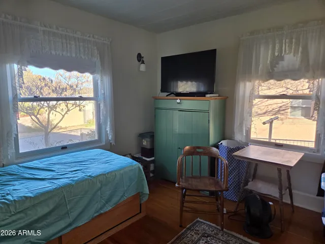 a bedroom with a bed window and a flat screen tv