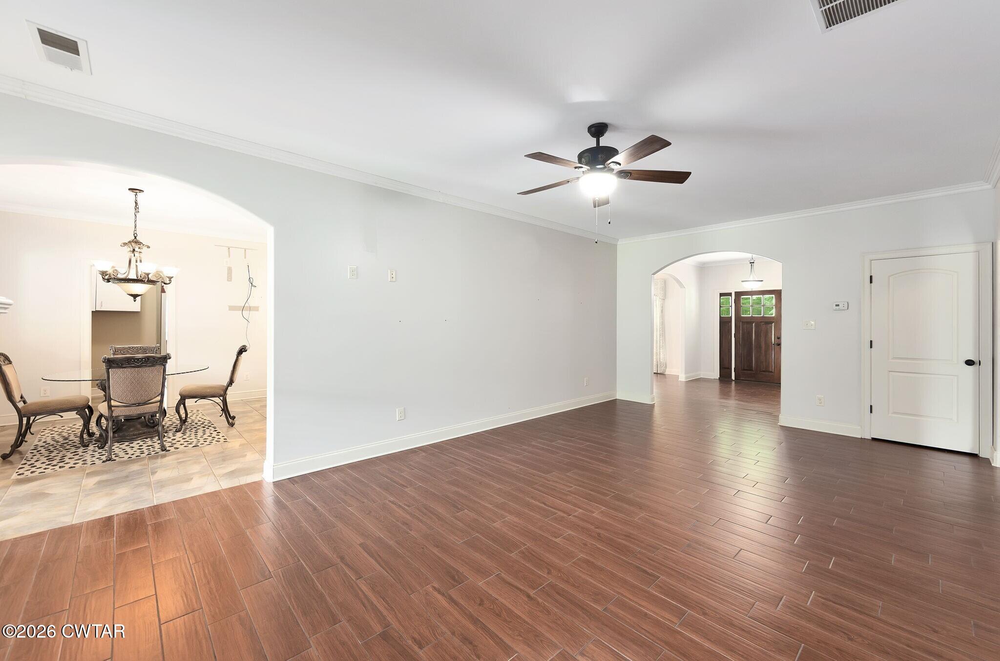 4080 Beech Bluff Road Beech Bluff, TN 38313 - Photo 22 of 41 an empty room with wooden floor chandelier fan and windows