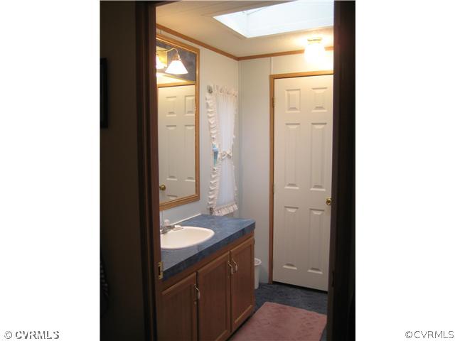 1222 Bible Road Crewe, VA 23930 - Photo 7 of 12 a bathroom with a granite countertop sink and a mirror