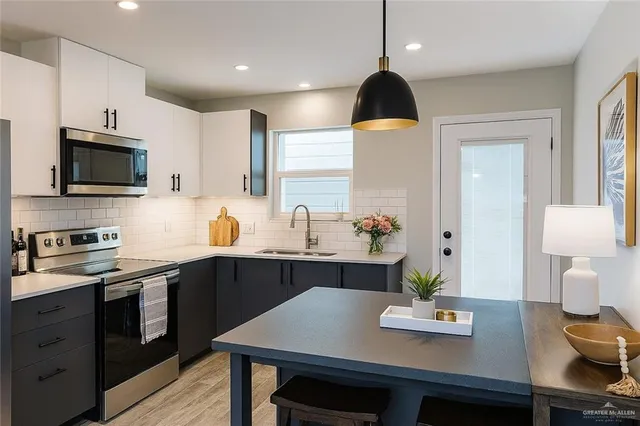 a kitchen with a sink appliances and cabinets