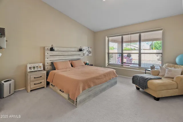 a bedroom with a bed and a couch with large window