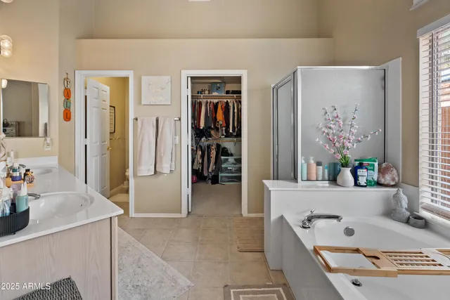 a bathroom with a tub a sink and a large mirror