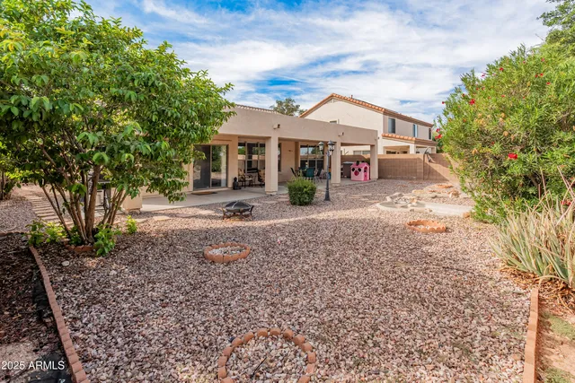 a front view of a house with a yard and a large tree