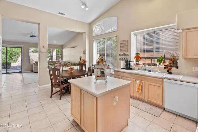 a open kitchen with stainless steel appliances granite countertop a sink and a large window