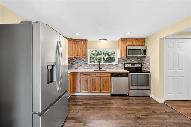 a kitchen with stainless steel appliances granite countertop a stove a sink and a refrigerator