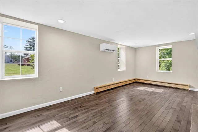 a living room with wooden floor and a fireplace