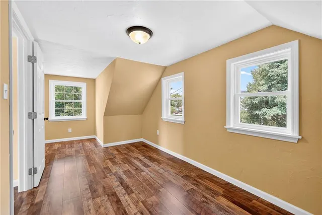 a view of a big room with wooden floor and windows