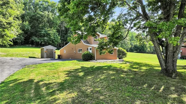 a aerial view of a house next to a yard and large tree