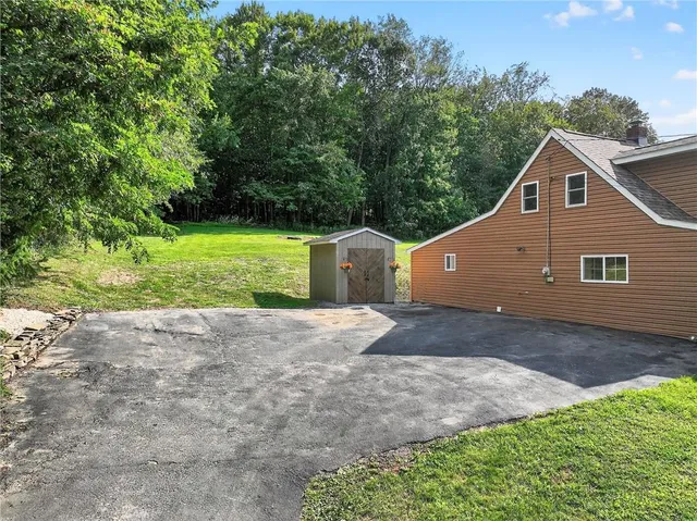 an aerial view of residential house with outdoor space and trees all around