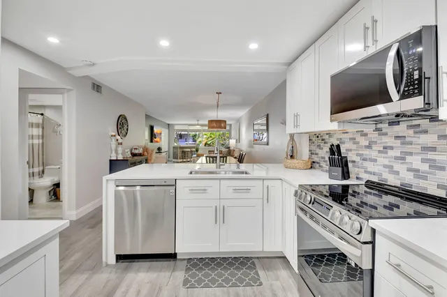 a kitchen with stainless steel appliances granite countertop a sink and a stove