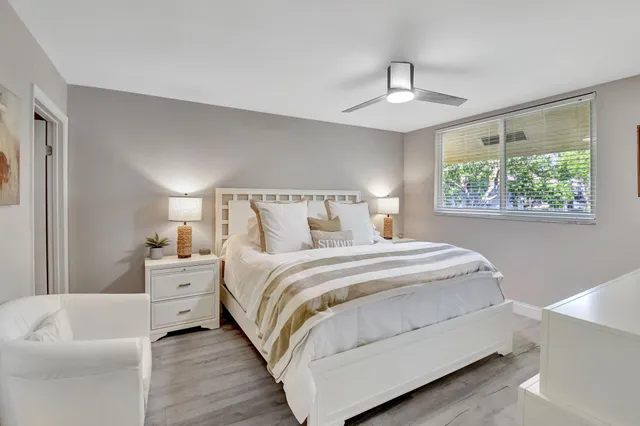 a bedroom with a bed and a flat tv screen on dresser