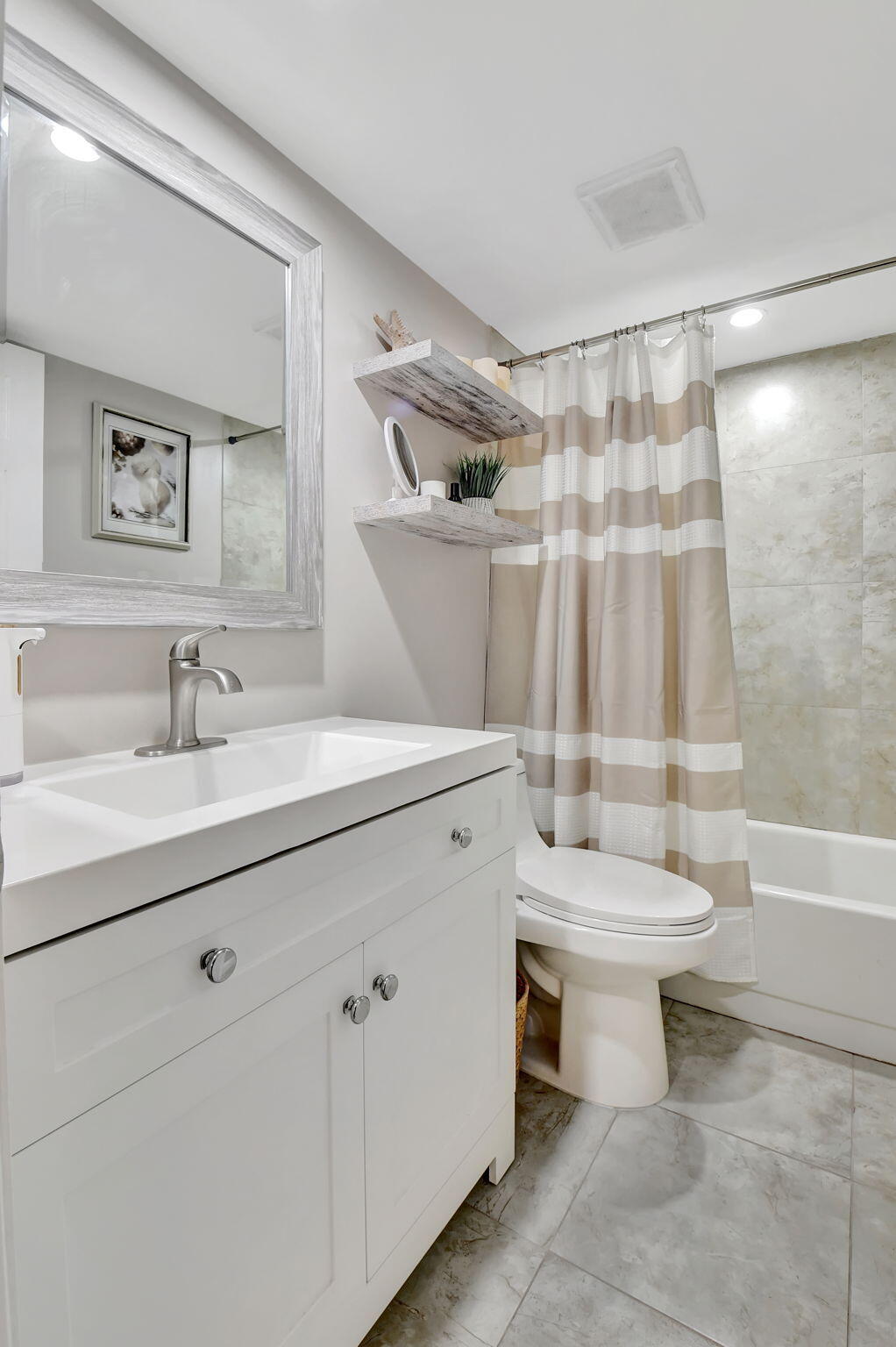 2805 Southwest 22nd Avenue, Unit 2050 Delray Beach, FL 33445 - Photo 17 of 36 a bathroom with a sink toilet a mirror and shower