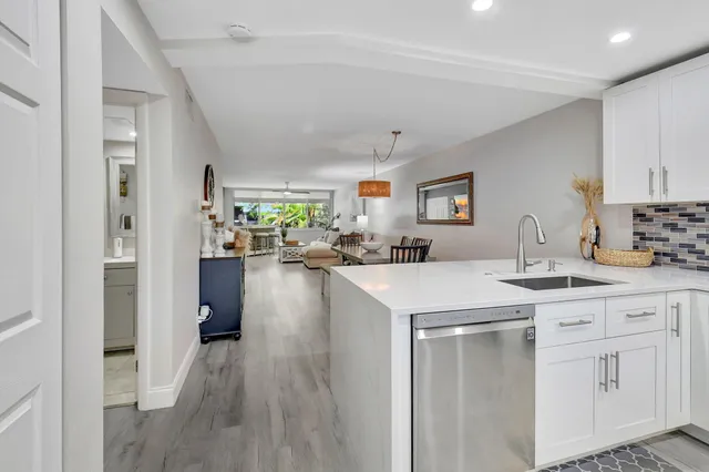 a kitchen with white cabinets appliances and a window
