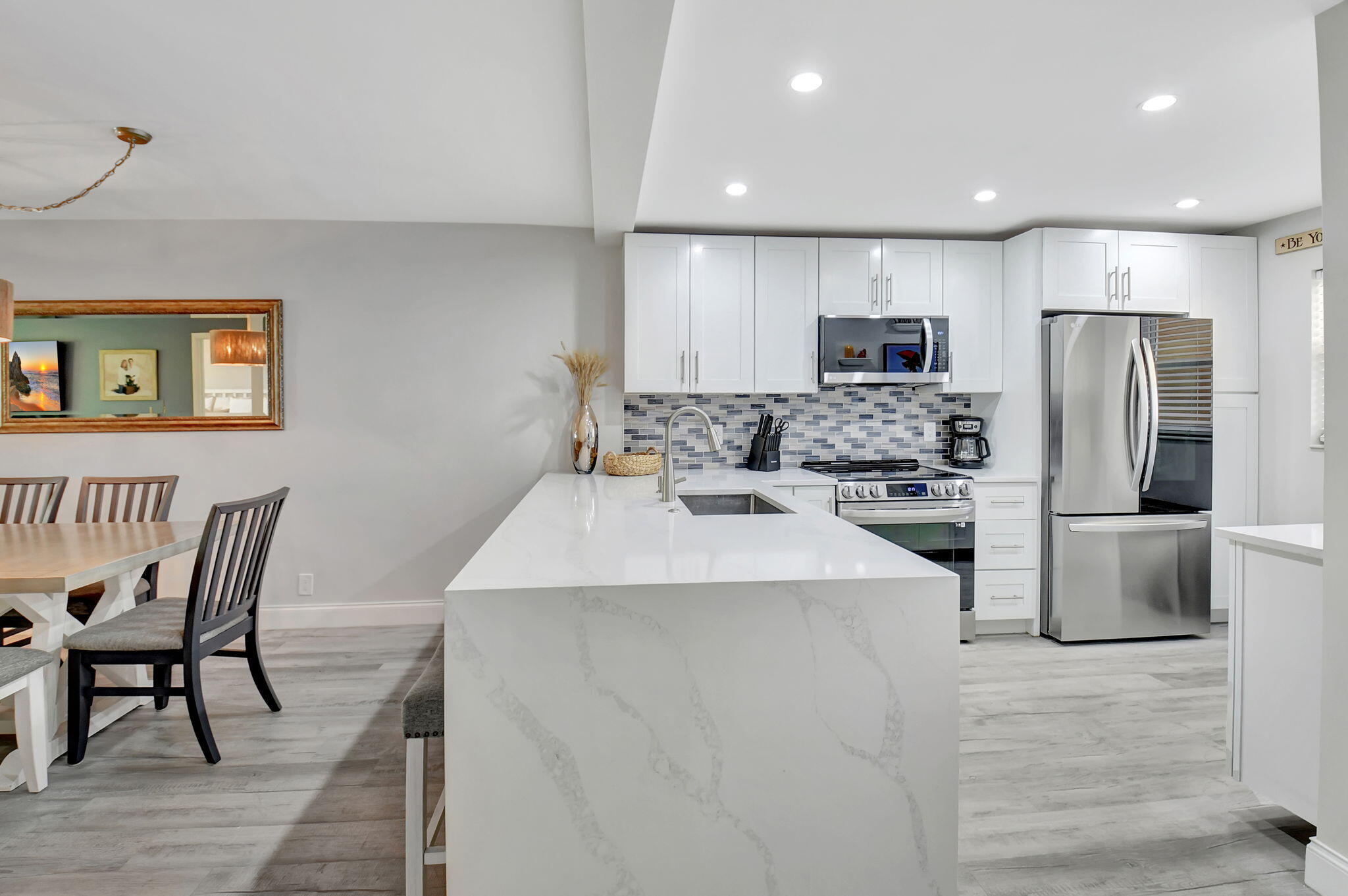 2805 Southwest 22nd Avenue, Unit 2050 Delray Beach, FL 33445 - Photo 5 of 36 a kitchen with stainless steel appliances a refrigerator stove microwave and cabinets