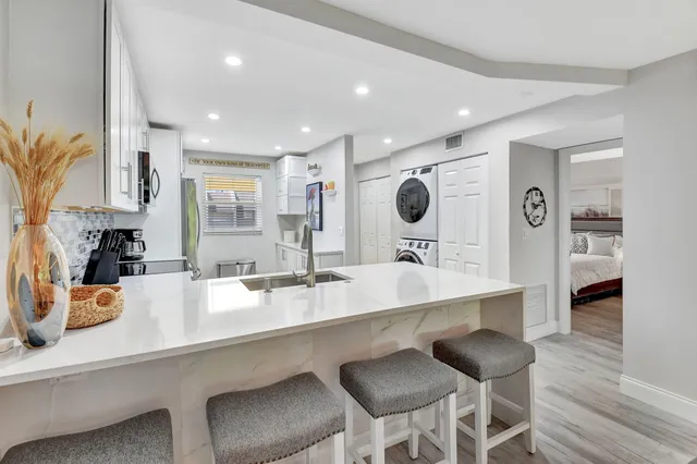 a kitchen with kitchen island granite countertop a sink and appliances