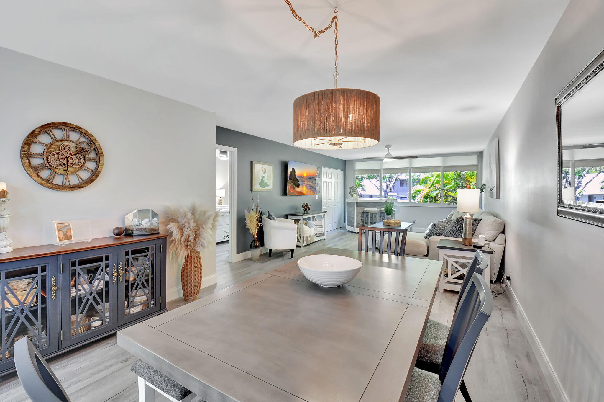 2805 Southwest 22nd Avenue, Unit 2050 Delray Beach, FL 33445 - Photo 10 of 36 a view of a dining room with furniture a chandelier and wooden floor