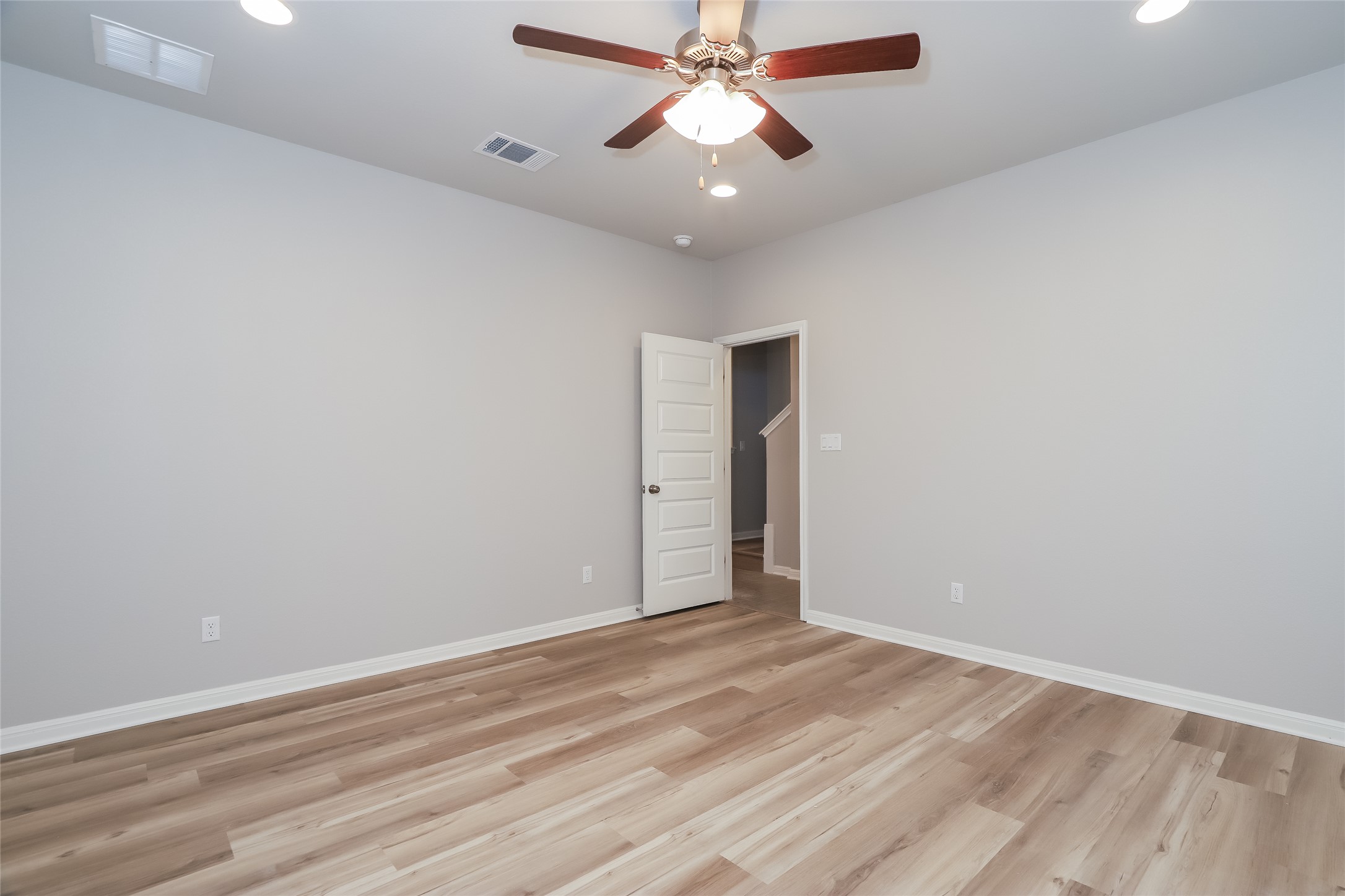 2724 Juniper Woods Road Leander, TX 78641 - Photo 12 of 21 A versatile room features a classic ceiling fan and enduring hardwood-style flooring, perfect for various living arrangements.