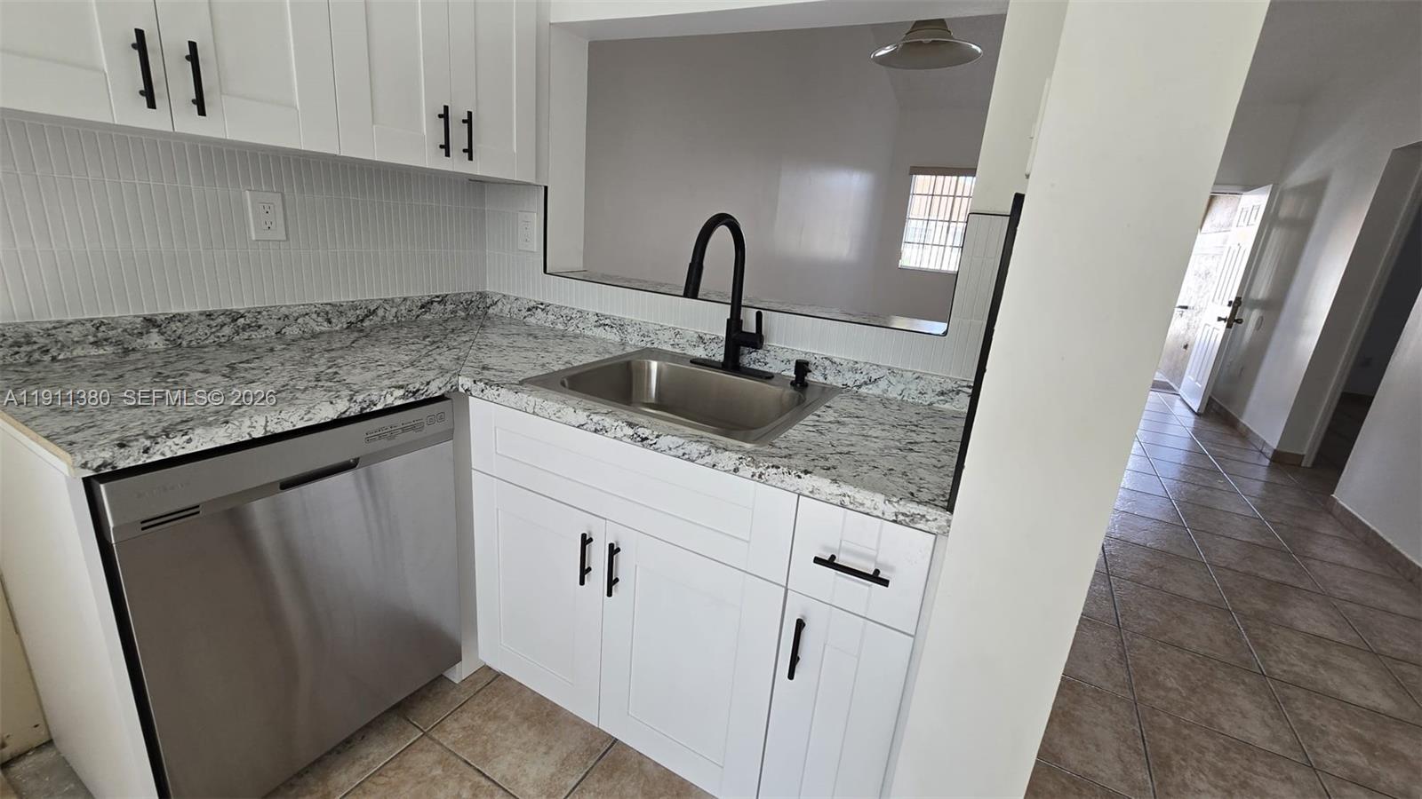 13120 Southwest 64th Terrace, Unit 1510 Miami, FL 33183 - Photo 18 of 25 a sink with granite countertop white cabinets and a sink