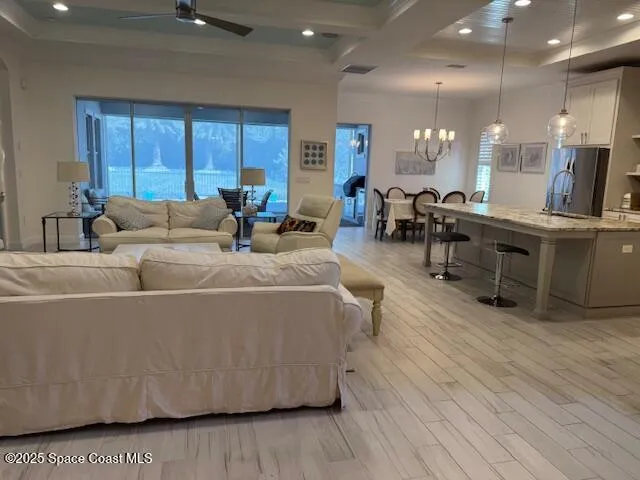 a living room with furniture a wooden floor and kitchen view