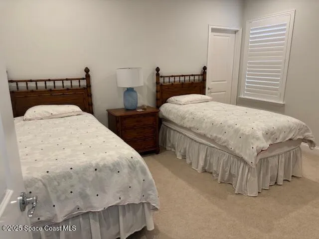 a bed sitting in a bedroom next to a window