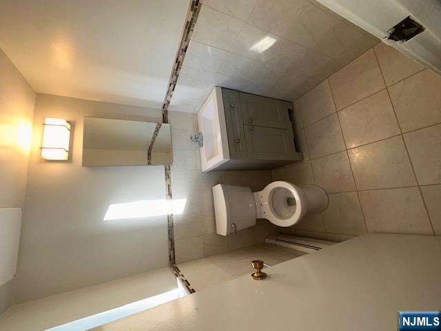 873 Main Street, Unit 2E Hackensack, NJ 07601 - Photo 15 of 23 a bathroom with a toilet sink and mirror